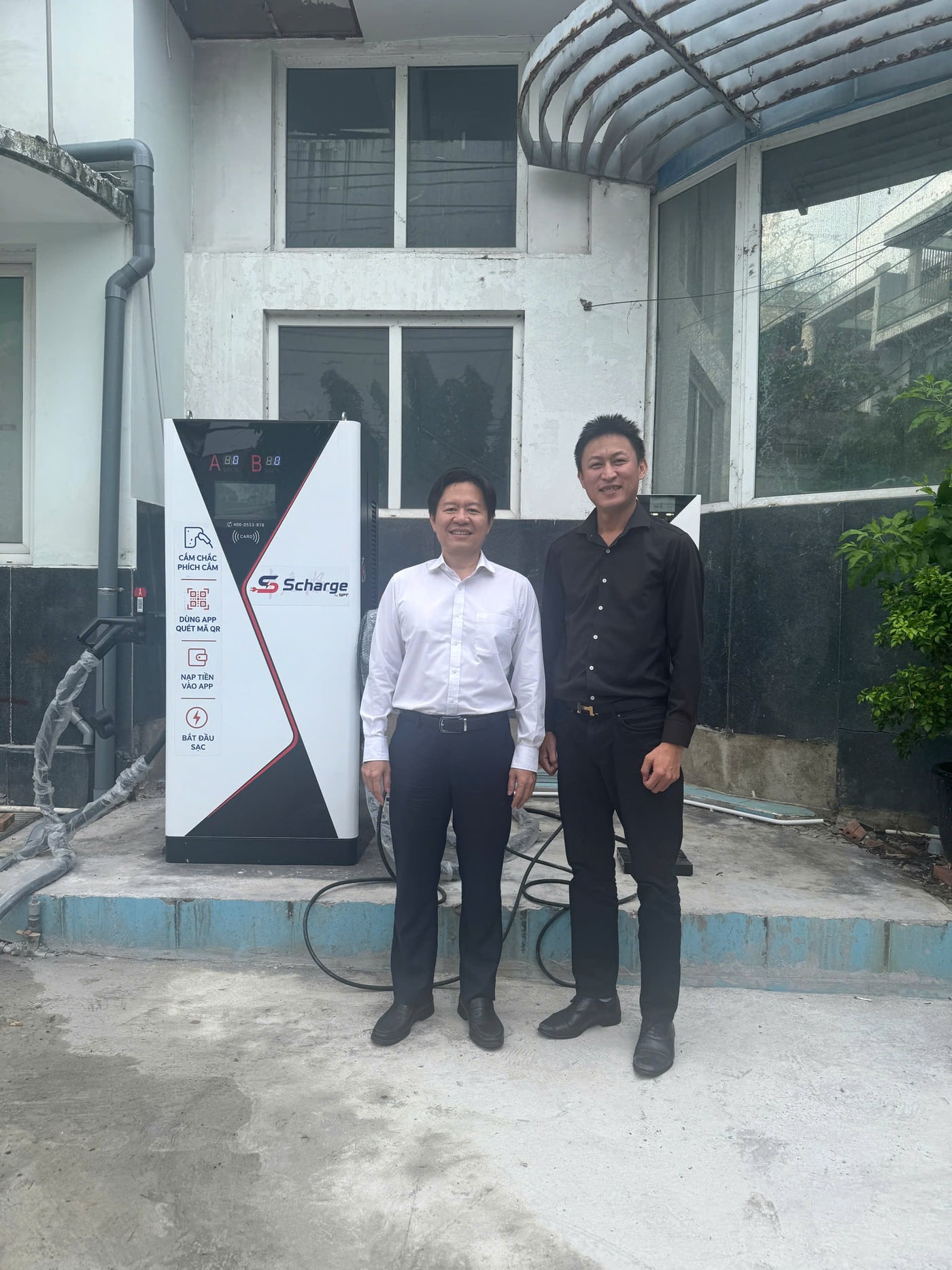 Tác giả cùng anh Đậu Trọng Hiển bên trụ sạc tại điểm dừng chân